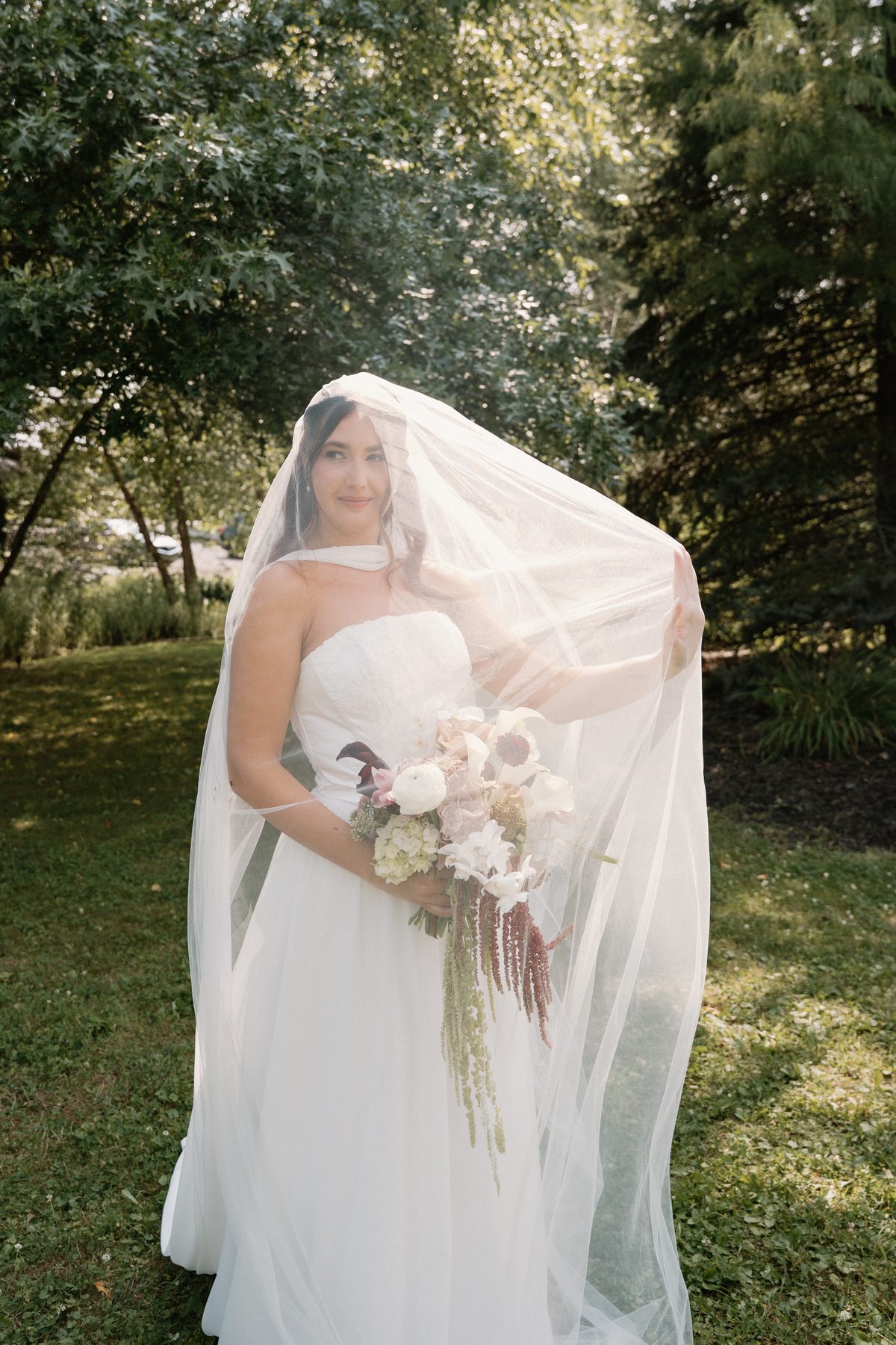 Bride under her veil holding a bouquet — bridal makeup by GISS Beauty, Pittsburgh PA