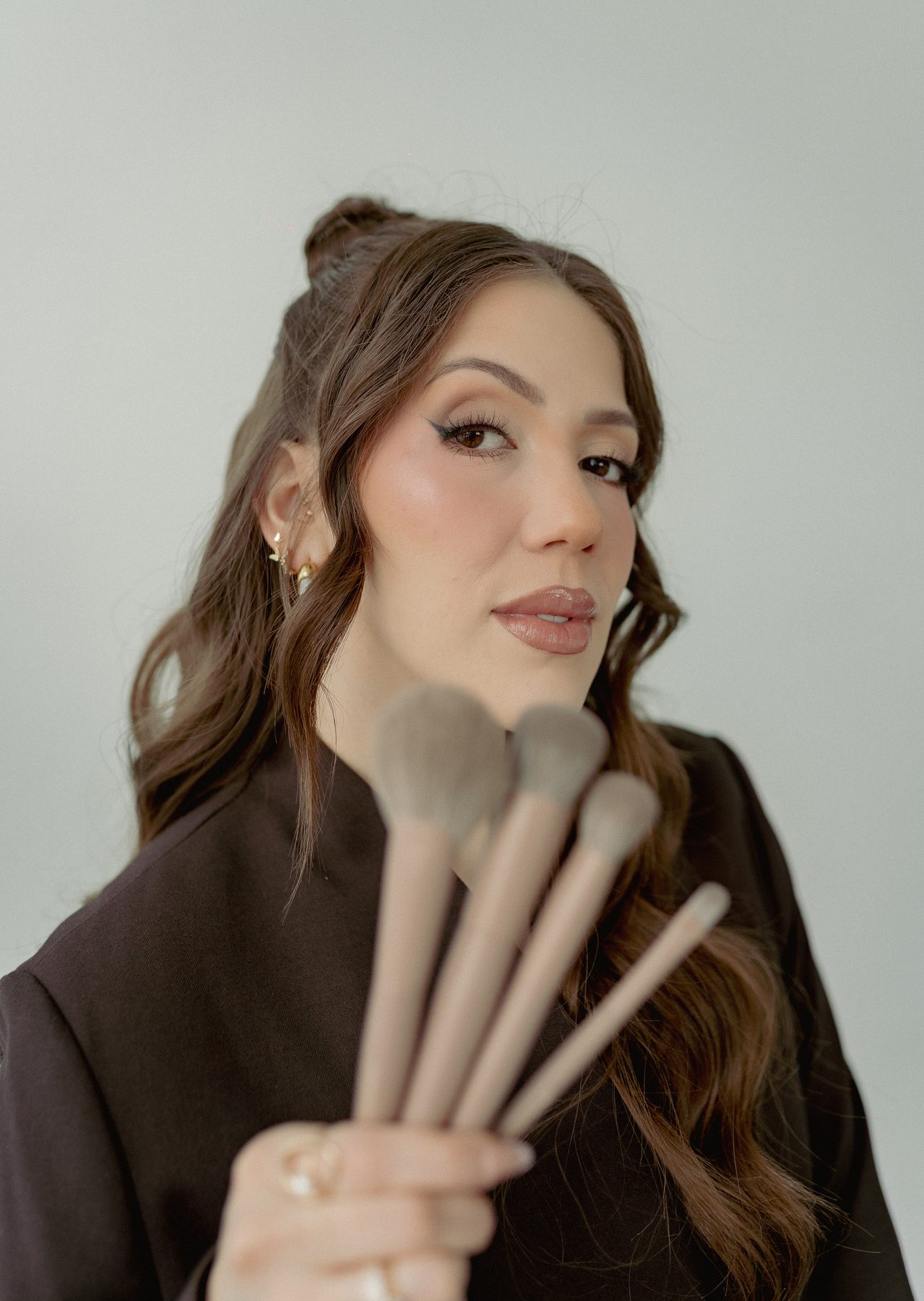 Gissell, luxury bridal makeup artist in Pittsburgh PA, holding professional brushes